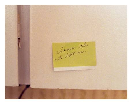 A collaged oil painting, the images are oriented in varying directions. It depicts a set of hands clasping red spotted flowers, a single lit white candle, a woman looking out onto a highway through veiled transparent curatins and a young girl at the table while her mother works in the kitcen behind her.